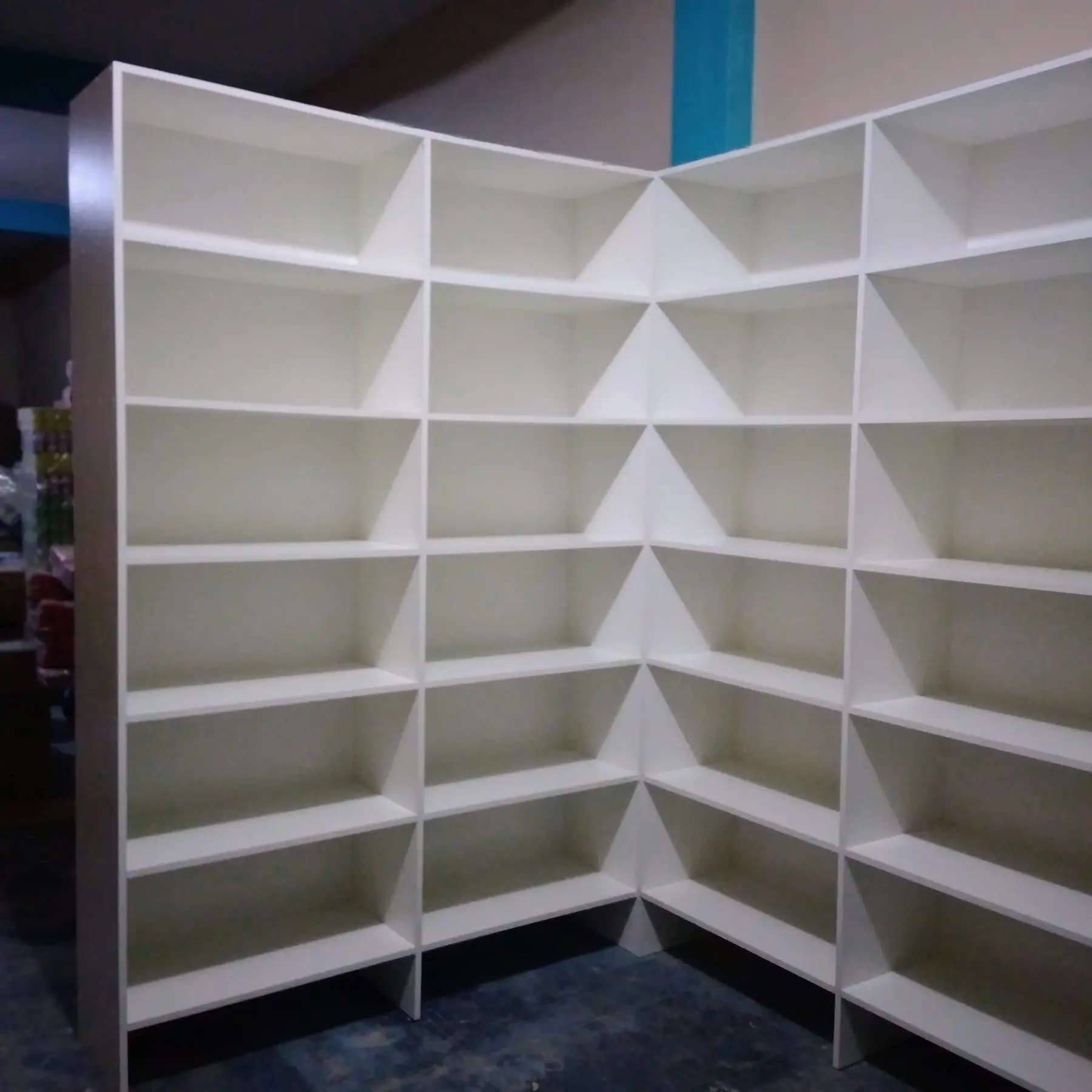 Estantería esquinera blanca con múltiples casilleros para tienda